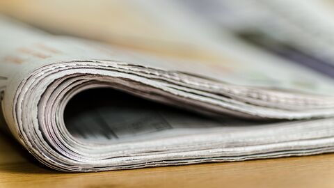 Pressekontakt umgeschlagene Zeitung auf Tisch