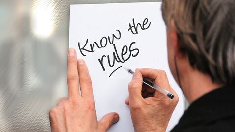 Jemand schreibt "Know the rules" auf einen Zettel