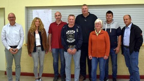 Acht Menschen vor einer Hauswand