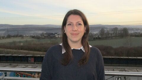 Frau Sandra Peppel, im Hintergrund Felder, Häuser und Hügel