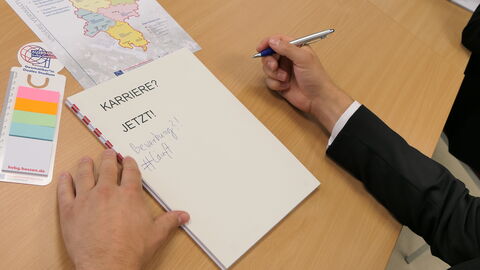 Auf einem Tisch liegt ein Blatt, auf dem das Wort Karriere steht