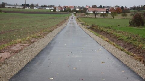 Weg zu Häusern Frisch geteerter Weg zu mehreren Häusern im Hintergrund