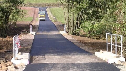 frisch geteerter Weg mit Planierraupe