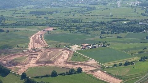 Luftbild einer Baustelle zwischen Feldern und Wiesen