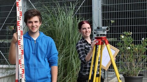 Die zwei Auszubildenden mit Messinstrumenten