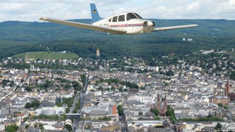 Bildflugprogramm Bildmontage eines Sportflugzeuges über einer Luftaufnahme von Wiesbaden