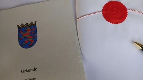 Vorderseite eines notariellen Vertrages, rechts daneben ein Siegel und die Spitze eines Stiftes