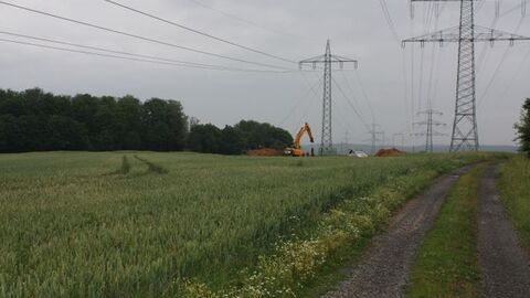 Neustadt - A 49 Feldweg, links daneben Feld mit Strommasten