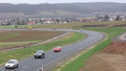 Weimar B 255 Straße zwischen Feldern mit Autos, im Hintergrund Häuser