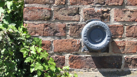 Amtliches Festpunktsystem Höhenbolzen in einer Mauer