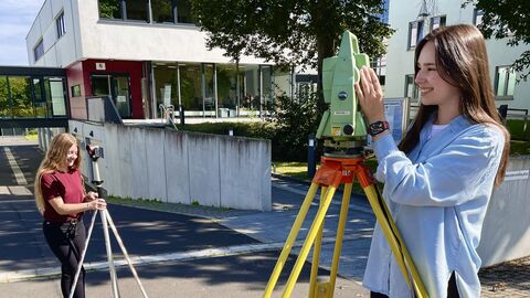 Praktikumsarbeiten im Freien 2 junge Menschen im Freien, eine Person steht an einem Messgerät