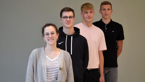 4 junge Menschen in einer Reihe hintereinander, etwas seitlich versetzt