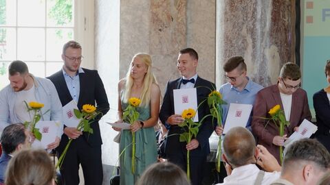 Freisprechungsfeier 2024 Mehrere Personen mit Zeugnissen und Sonnenblume