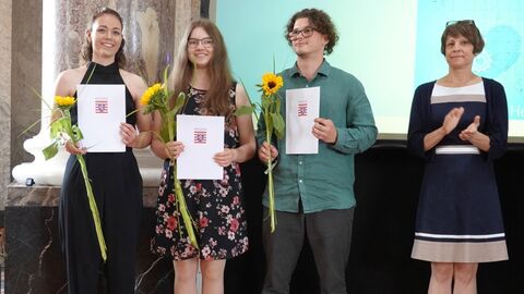 Freisprechungsfeier 2024 4 Personen vor einer Präsentationswand