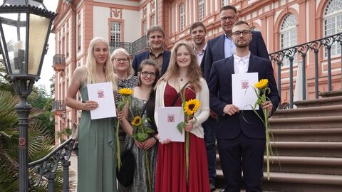 Freisprechungsfeier 2024 Mehrere Personen mit Zeugnissen auf der Treppe vor dem Schloss