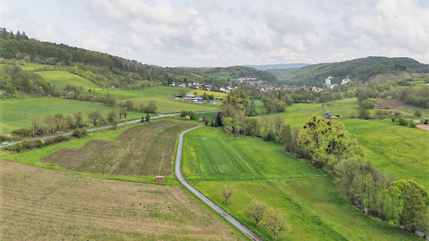 Witzenhausen Gelster Hügelige Landschaft mir Feldern und Wegen, im Hintergrund Häuser