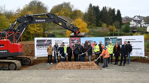 Mehrere Personen hinter einem Sandhaufen, symbolischer Spatenstich