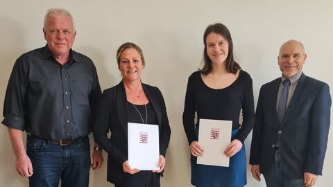 4 Personen schauen in Richtung Kamera.