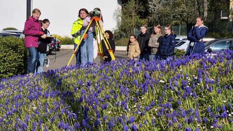 GirlsDay Teilnehmerinnen mit Messinstrument vor blühendem Lavendelbeet