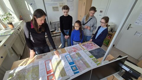 GirlsDay Teilnehmerinnen vor Schreibtisch mit Landkarten