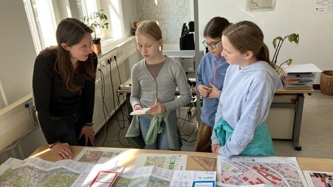 GirlsDay Teilnehmerinnen vor Schreibtisch mit Landkarten