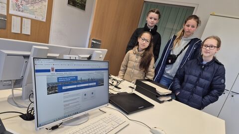 GirlsDay Teilnehmerinnen vor Schreibtisch mit PC Monitor