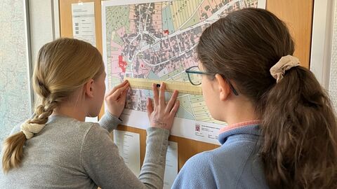 GirlsDay Teilnehmerinnen messen auf einer Karte an der Wand