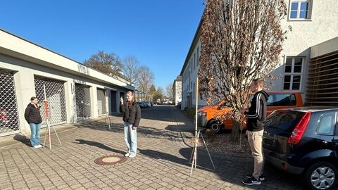 Mehrere Personen in einem Hof beim messen