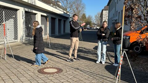 Mehrere Personen in einem Hof beim messen