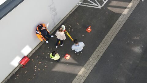 Vier Personen mit Messinstrumet aus der Luft aufgenommen