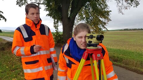 Zwei junge Menschen bei einer Vermessung