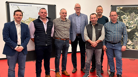 Mehrere Personen in einem Raum, Blick zur Kamera