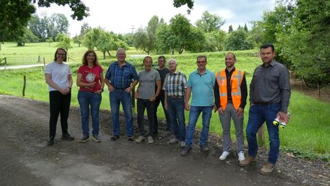 Personen stehen nebeneinander auf einem Weg