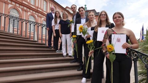 Prüflinge mit Zeugnis und Kollegen auf der Treppe des Biebricher Schlosses
