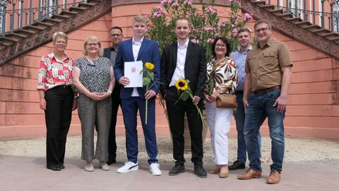 Prüflinge mit Zeugnis und Kollegen vor der Treppe des Biebricher Schlosses