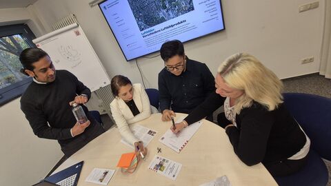 Duales Studium, Ausbildung höherer Dienst 4 Personen vor einem Tisch
