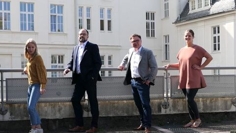 4 Personen stehen in einer Reihe