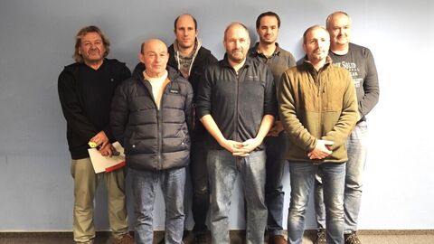 7 Personen nebeneinander vor einer Wand