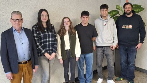 6 Personen nebeneinander vor einer Wand