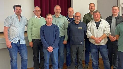 9 Personen vor einer Wand
